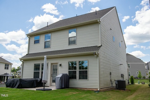 rear view of property with cooling unit, a patio area, and a yard