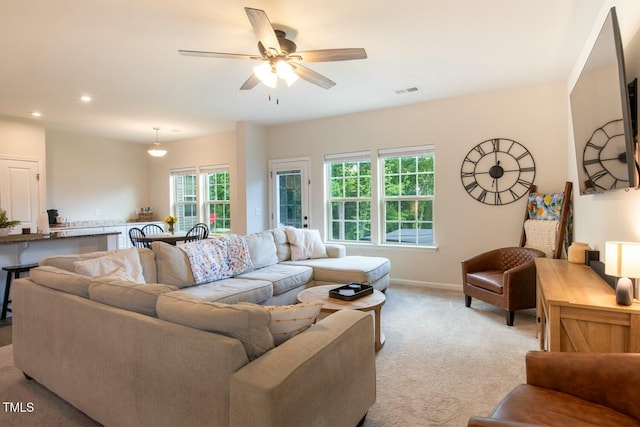 living room with light colored carpet and ceiling fan