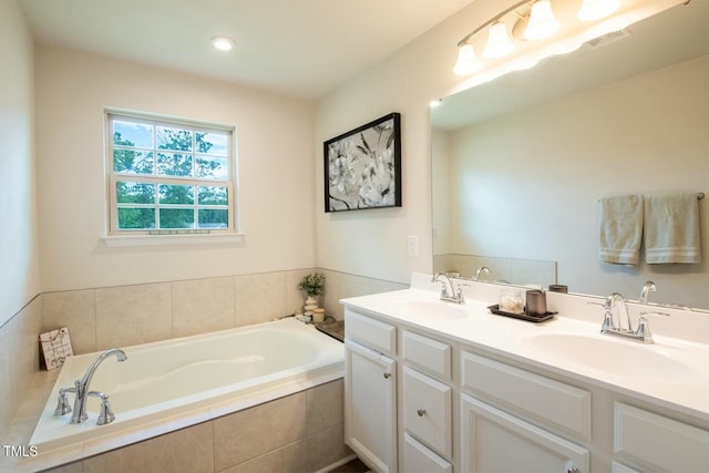 bathroom with vanity and a relaxing tiled tub