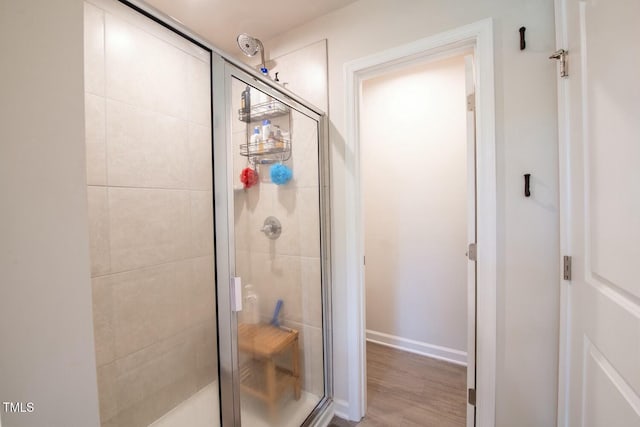 bathroom featuring hardwood / wood-style flooring and walk in shower