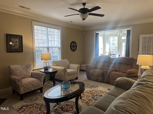 carpeted living room featuring ornamental molding and ceiling fan