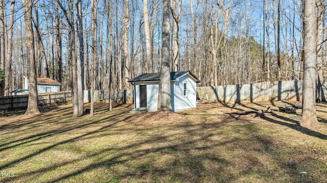 view of yard featuring an outbuilding, a fenced backyard, and a shed