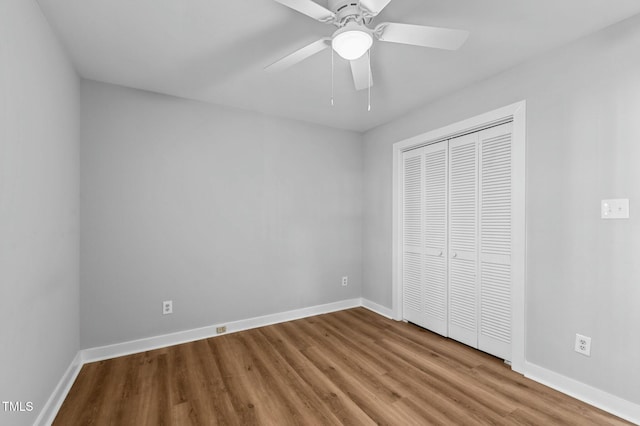 unfurnished bedroom featuring ceiling fan, light hardwood / wood-style floors, and a closet