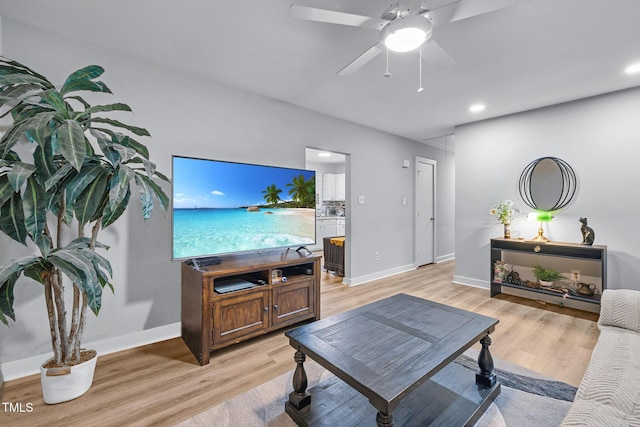 living room with baseboards, light wood-style floors, and attic access