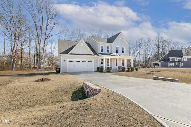 view of front of home with a garage, a front yard, and covered porch