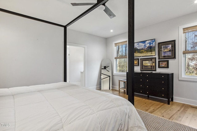 bedroom with multiple windows, light hardwood / wood-style floors, and ceiling fan