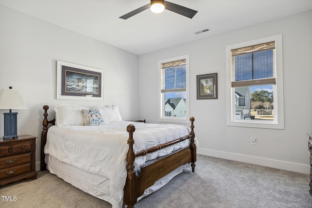 bedroom with multiple windows, light colored carpet, and ceiling fan