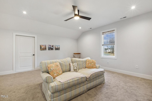 carpeted living room with ceiling fan and vaulted ceiling