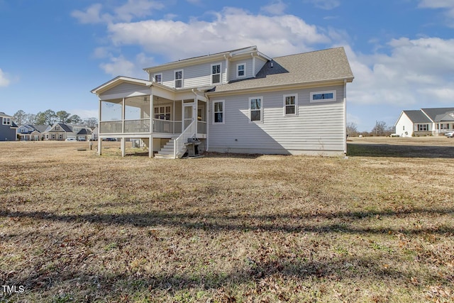 back of house with a sunroom and a lawn