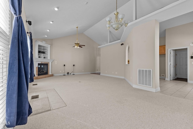 unfurnished living room featuring light colored carpet, high vaulted ceiling, and ceiling fan with notable chandelier