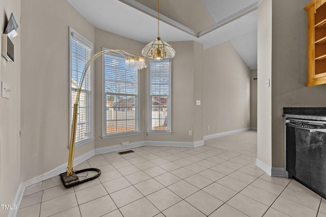 unfurnished dining area with plenty of natural light, light tile patterned floors, and a chandelier