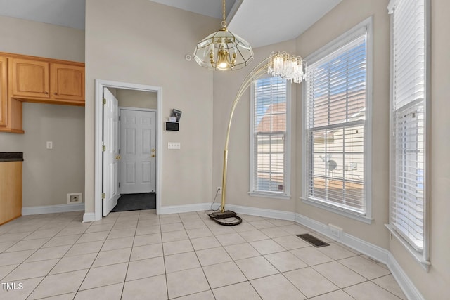 unfurnished dining area with light tile patterned floors and a healthy amount of sunlight