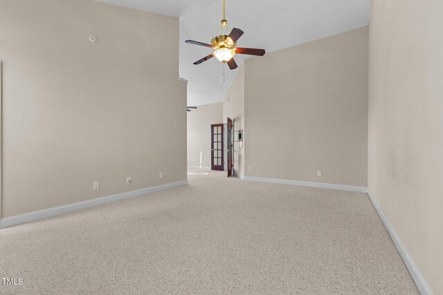 spare room featuring high vaulted ceiling, carpet flooring, and ceiling fan