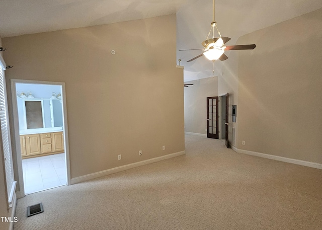 carpeted empty room featuring ceiling fan and high vaulted ceiling