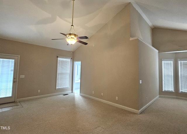 unfurnished living room with high vaulted ceiling, light colored carpet, and ceiling fan