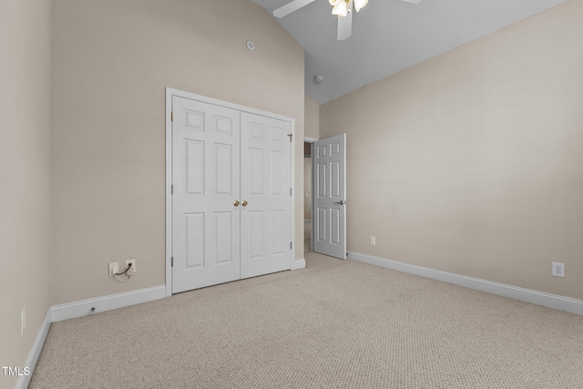 unfurnished bedroom featuring vaulted ceiling, light carpet, ceiling fan, and a closet