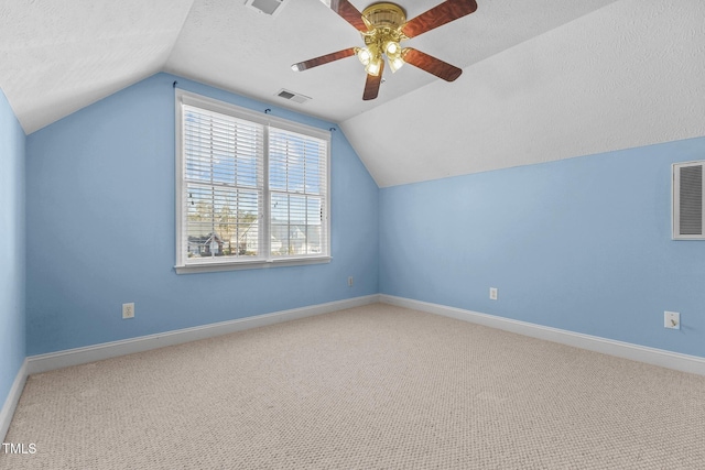 additional living space with lofted ceiling, carpet floors, a textured ceiling, and ceiling fan