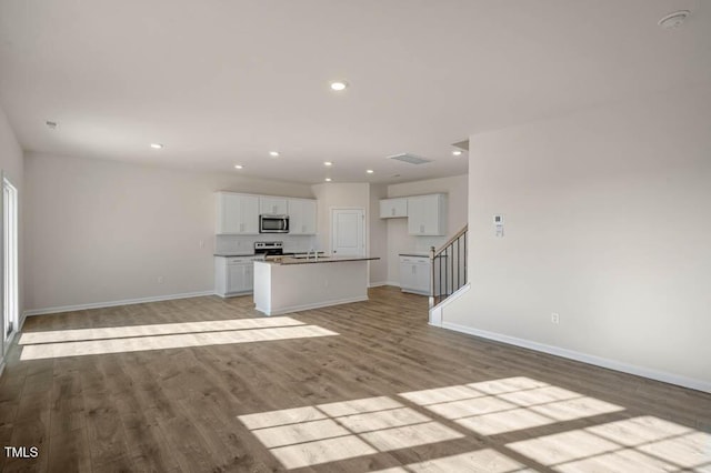 unfurnished living room featuring light wood-type flooring and sink