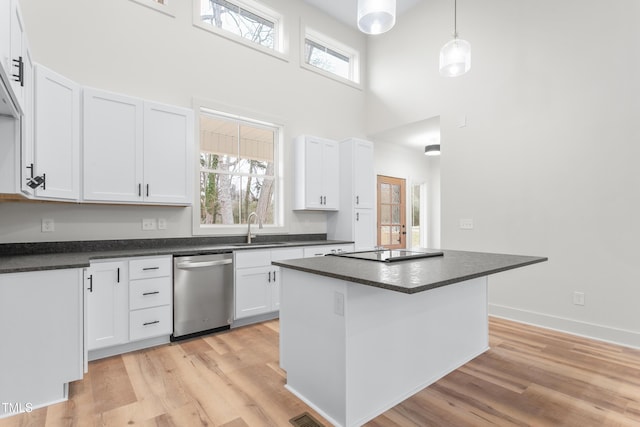 kitchen featuring stainless steel dishwasher, pendant lighting, sink, white cabinets, and a center island