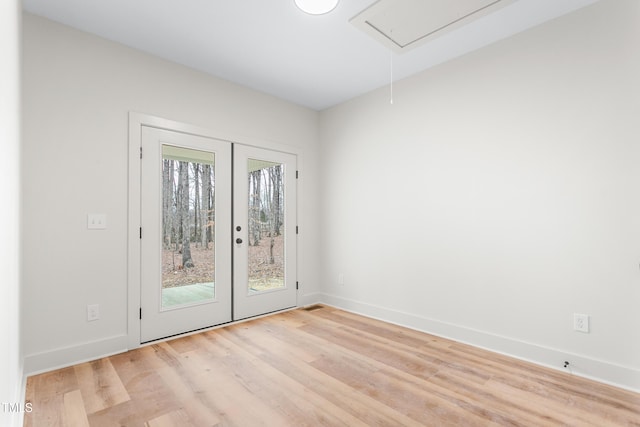 unfurnished room featuring light hardwood / wood-style floors and french doors