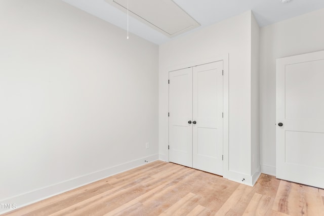 unfurnished bedroom with light wood-type flooring and a closet