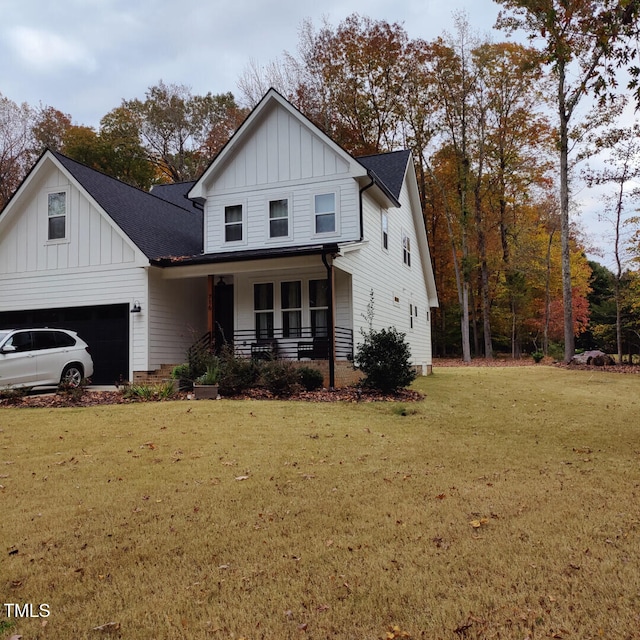 view of front of home featuring a garage, a front yard, and covered porch