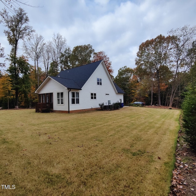 view of side of home with a sunroom and a lawn