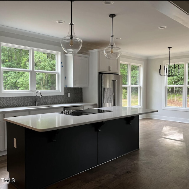 kitchen featuring a large island, decorative light fixtures, white cabinets, decorative backsplash, and high end refrigerator