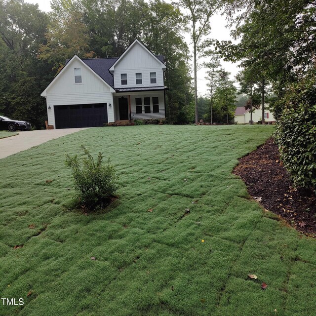 modern inspired farmhouse with board and batten siding, concrete driveway, a garage, and a front yard