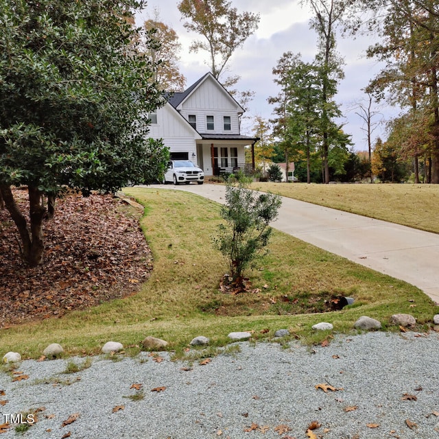 view of front of property with a garage, board and batten siding, concrete driveway, and a front yard