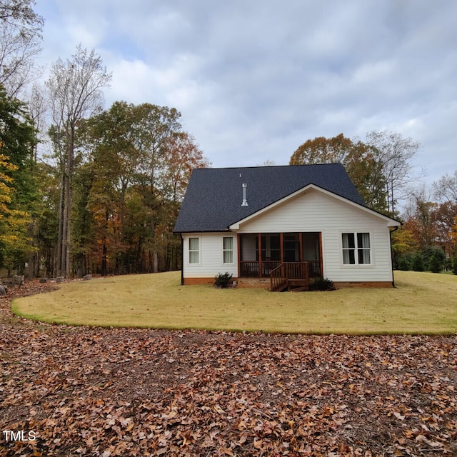 back of house with a lawn, roof with shingles, and a sunroom