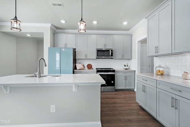 kitchen with gray cabinetry, sink, pendant lighting, and stainless steel appliances