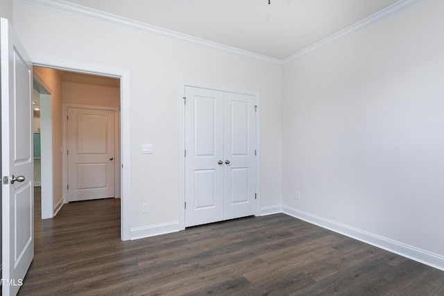 unfurnished bedroom featuring ornamental molding, dark wood-type flooring, and a closet