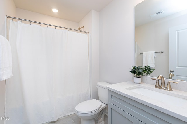 bathroom featuring vanity, tile patterned floors, and toilet