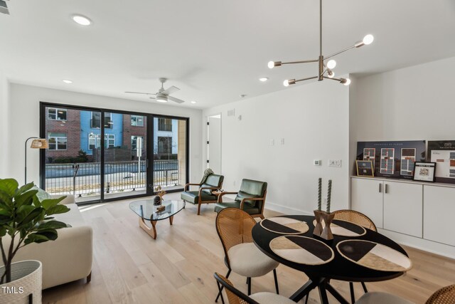 dining space with recessed lighting, visible vents, light wood-style flooring, and ceiling fan with notable chandelier