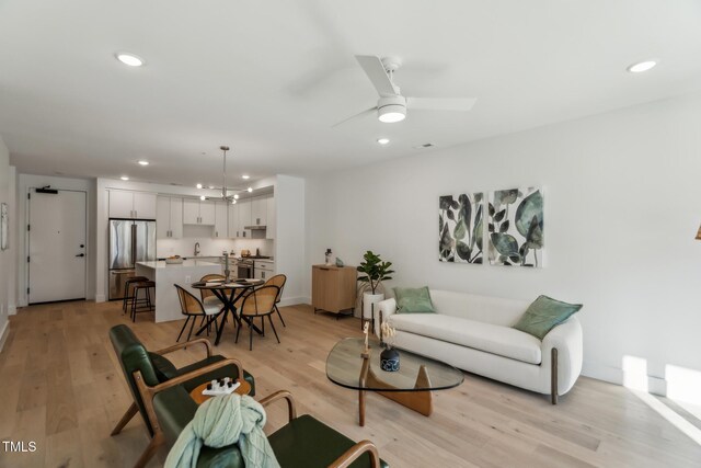 living area with recessed lighting, light wood-style flooring, and a ceiling fan