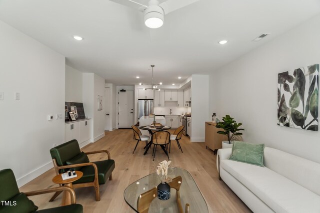 living area featuring recessed lighting, visible vents, baseboards, and light wood finished floors