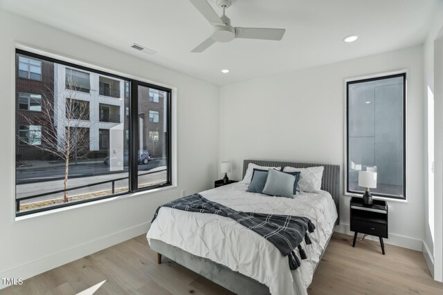 bedroom featuring wood finished floors, visible vents, and baseboards