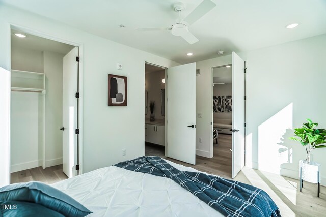 bedroom featuring a walk in closet, wood finished floors, and a closet