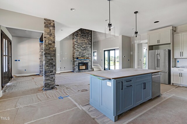 6509 Zebulon Rd, Wake Forest, NC 27587 - kitchen with appliances with stainless steel finishes, a kitchen island, a stone fireplace, ornate columns, and white cabinets
