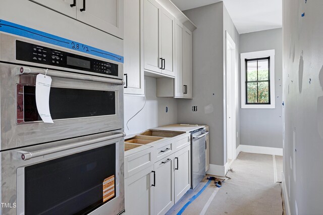 6509 Zebulon Rd, Wake Forest, NC 27587 - kitchen featuring stainless steel double oven, white cabinetry, baseboards, and light countertops