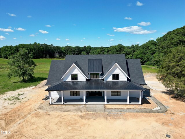 6509 Zebulon Rd, Wake Forest, NC 27587 - view of front facade with covered porch, metal roof, and a view of trees