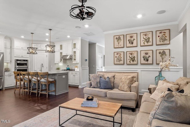 living room with ornamental molding, dark hardwood / wood-style floors, and sink