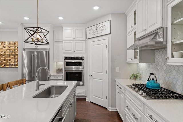 kitchen featuring sink, hanging light fixtures, stainless steel appliances, decorative backsplash, and white cabinets