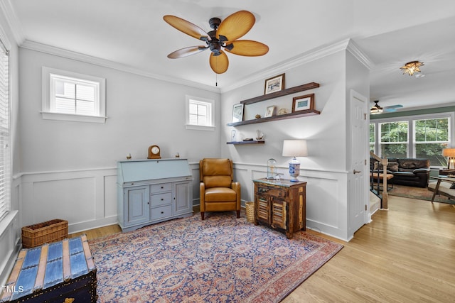 sitting room with ornamental molding, ceiling fan, and light wood-type flooring