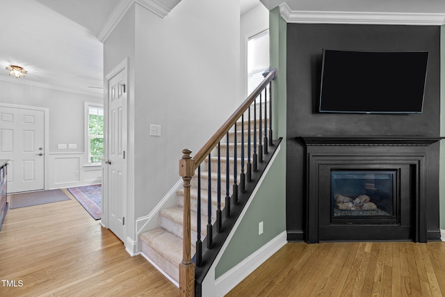 staircase featuring crown molding and hardwood / wood-style flooring