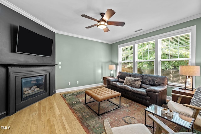 living room featuring crown molding, ceiling fan, and light wood-type flooring