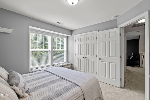 bedroom featuring light carpet and a closet