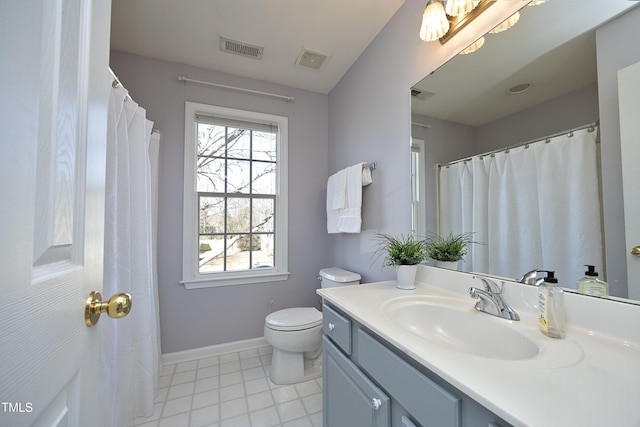 bathroom featuring vanity, toilet, and plenty of natural light