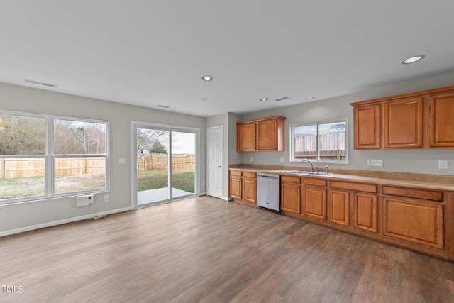 kitchen with visible vents, brown cabinets, wood finished floors, stainless steel dishwasher, and recessed lighting